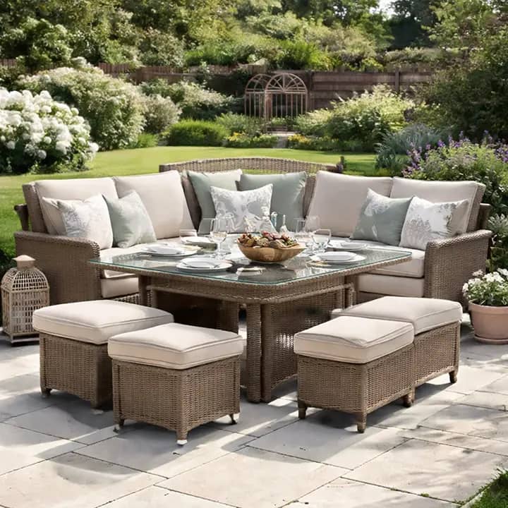 Rattan garden furniture set on a patio in a UK garden with sofa seating, dining table and outdoor cushions